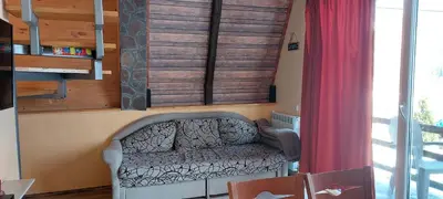 a living room with a couch and a red curtain at Vili Bilyana in Crni Vrh