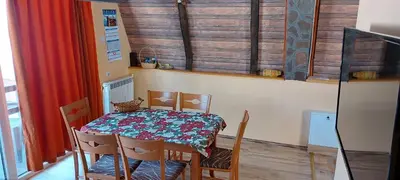 a dining room with a table and chairs and a window at Vili Bilyana in Crni Vrh