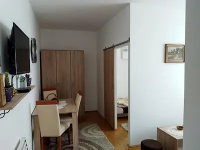 a small apartment with a dining table and a bedroom at Apartman Krstić in Vrnjačka Banja