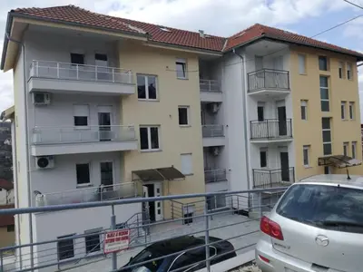 a building with a car parked in front of it at Apartman Krstić in Vrnjačka Banja