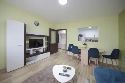 a living room with a table and chairs at Apartman DIAMOND-LUX in Jagodina