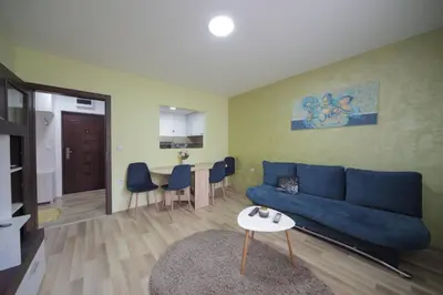 a living room with a blue couch and a table at Apartman DIAMOND-LUX in Jagodina