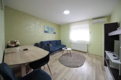 a living room with a table and a blue couch at Apartman DIAMOND-LUX in Jagodina