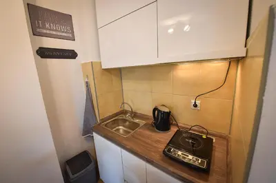 a small kitchen with a sink and a counter top at Urban Apartment in Niš
