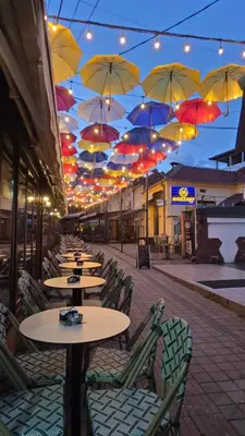a row of tables and chairs with umbrellas above them at Apartman Veselinovic Free PARKING in Vranje