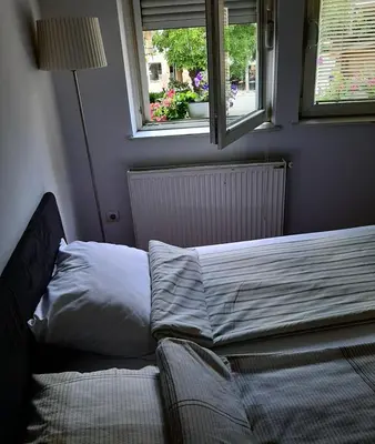 a bed sitting in a bedroom with a window at Apartman Veselinovic Free PARKING in Vranje