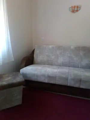 a couch sitting in a room with a window at Guest House Green view in Pirot