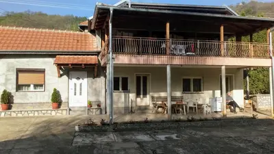 a house with a balcony and a table and chairs at Guest House Green view in Pirot