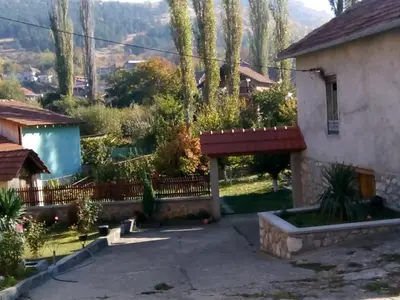 a house with a fence and a courtyard at Guest House Green view in Pirot