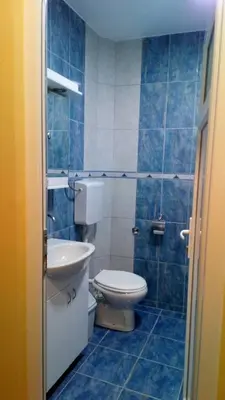 a blue tiled bathroom with a toilet and a sink at Guest House Green view in Pirot