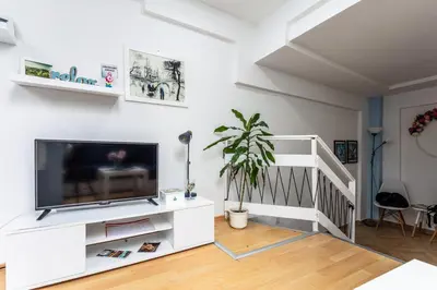 a living room with a flat screen tv on a white entertainment center at SB centar apartmani in Niš