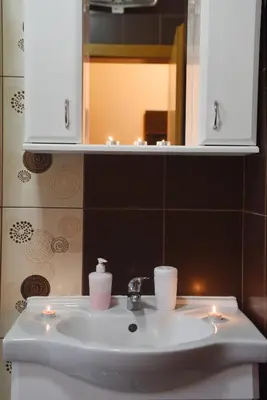 a bathroom sink with two candles and a mirror at Apartment Matovic in Vrnjačka Banja