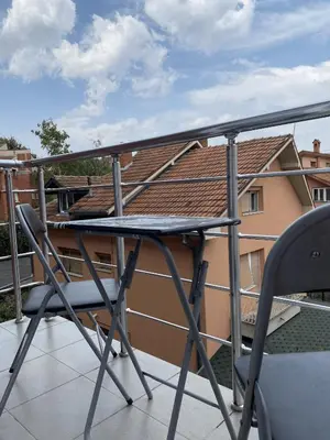 a table and a chair on a balcony at Apartment Matovic in Vrnjačka Banja