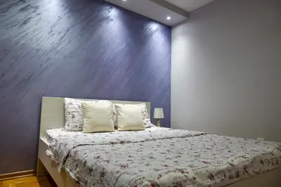 a bedroom with a bed with a large wall at Apartment Marijana in Vrnjačka Banja