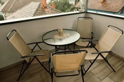 a table and four chairs on a balcony with a table and chairsktop at Apartment Marijana in Vrnjačka Banja
