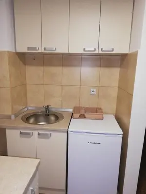 a small kitchen with a sink and a white refrigerator at Laguna apartman 2 in Niš