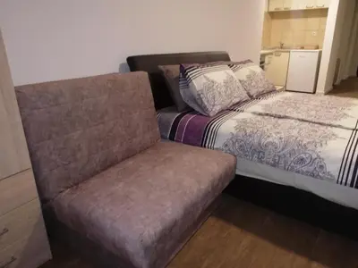 a bed and a couch in a room at Laguna apartman 2 in Niš