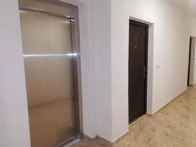 a walk in shower in a room with a door at Laguna apartman 2 in Niš
