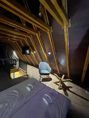 a bedroom with a bed and a chair in a room at Resavsko Etno Selo in Despotovac