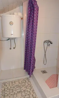 a shower with a purple shower curtain in a bathroom at Apartman Kaća in Vrnjačka Banja