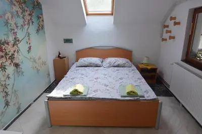 a bedroom with a bed with two hats on it at Apartman Kaća in Vrnjačka Banja