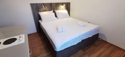 a bedroom with a bed with two slippers on it at Apartments Banjica in Soko Banja