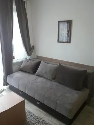 a couch in a living room with a window at Stefan apartmani in Kopaonik