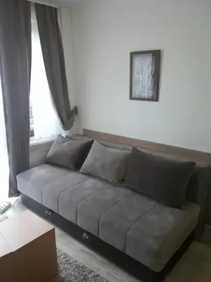 a living room with a couch in front of a window at Stefan apartmani in Kopaonik