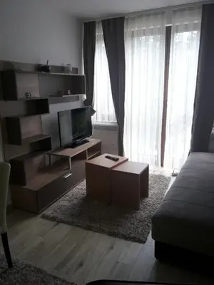 a living room with a tv and a couch and a table at Stefan apartmani in Kopaonik