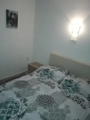 a bed with a flowered blanket on top of it at Stefan apartmani in Kopaonik