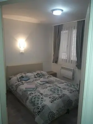 a bedroom with a bed and a light on the wall at Stefan apartmani in Kopaonik