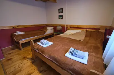 a room with two beds with towels on them at Golema Reka in Crni Vrh