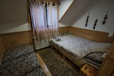 a small room with a bed and a window at Golema Reka in Crni Vrh