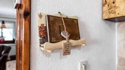 a wooden object hanging on a wall with a book at Vila Seka in Kopaonik