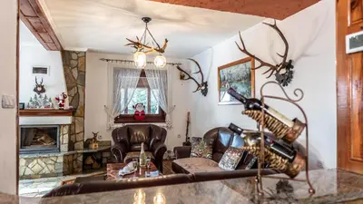 a living room with antlers on the wall at Vila Seka in Kopaonik