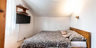 a small bedroom with a bed in a room at Vila Seka in Kopaonik