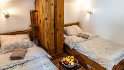 two twin beds in a room with a bowl of fruit at Vila Seka in Kopaonik