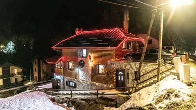 a wooden house with a red roof in the snow at Vila Seka in Kopaonik