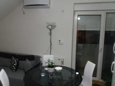 a living room with a glass table and a couch at Jasna Apartman in Vrnjačka Banja