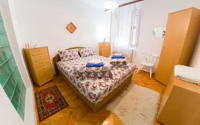a small bedroom with a bed and a dresser at Apartmani Didić in Soko Banja