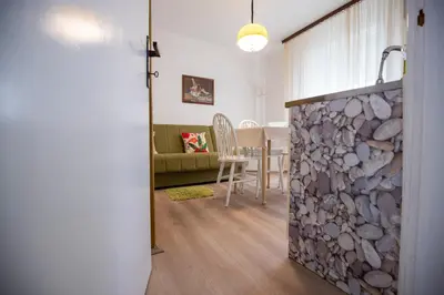 a living room with a stone fireplace and a table at Apartmani Didić in Soko Banja