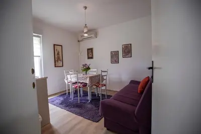 a living room with a purple couch and a table at Apartmani Didić in Soko Banja