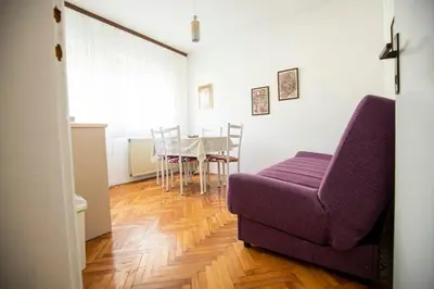 a living room with a purple couch and a table at Apartmani Didić in Soko Banja