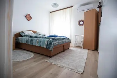 a bedroom with a bed and a large window at Apartmani Didić in Soko Banja
