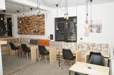 a restaurant with tables and chairs and a couch at AS Apartments in Kopaonik