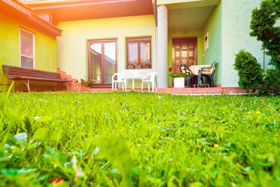 a house with chairs and a bench in the yard at Apartmani Slavica in Jagodina