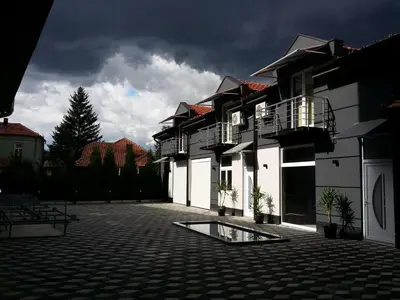 a group of buildings with a cloudy sky in the background at APARTMANI LAVAZZA in Vlasotince
