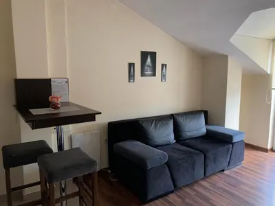 a living room with a blue couch and a table at APARTMANI LAVAZZA in Vlasotince