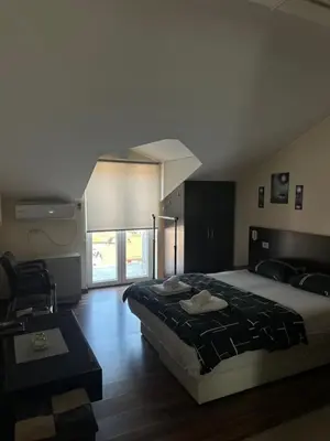 a bedroom with a large bed and a window at APARTMANI LAVAZZA in Vlasotince