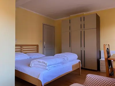 a bedroom with two beds and a closet at Apartments and Rooms Vicko in Brzeće
